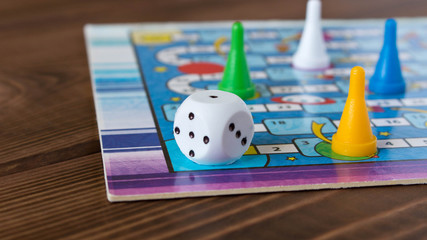 Multi-colored game chips with dice on the playing board. Board game