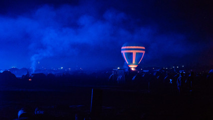 Obraz na płótnie Canvas Hot air balloon flying over spectacular Cappadocia under the sky with milky way and shininng star at night (with grain)