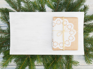 Fir tree branch with present, white nameplate. Winter holidays concept