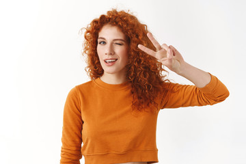 Girl in good mood staying bright side. Cheerful redhead female student showing peace, victory sign...
