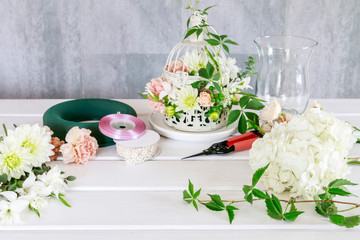 Woman shows how to make wedding table decoration with wreath and candle