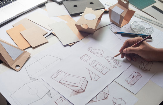 Designer sketching drawing design Brown craft cardboard paper product eco packaging mockup box development template package branding Label . designer studio concept .