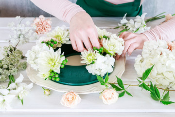 Woman shows how to make wedding table decoration with wreath and candle © agneskantaruk