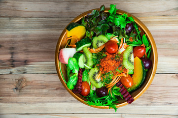 Top view various fresh healthy mixed vegetables salad serving in wooden bowl.
