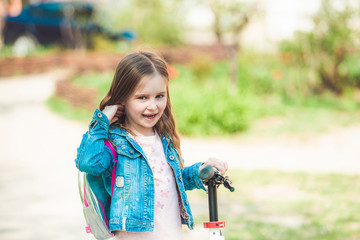 Little girl riding on scooter