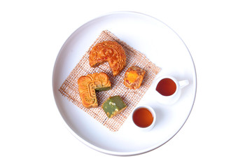 Round mooncake.8 grains and salted eggs and squred mooncake filled red beans, stirred in green tea and chopped macadamia nuts served  with tea and teapot.