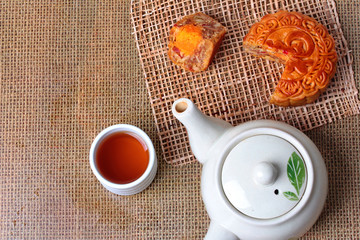 Round mooncake filled.8 grains and salted eggs served with tea and the teapot.