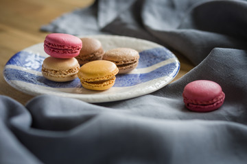 Macaroons in a plate on a wooden table close-up.
