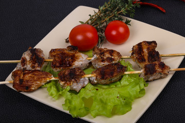 Pork kebab skewers in the plate with salad leaves and tomatoes
