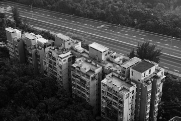 a monochrome top-down view of residential buildings besides a coastal highway in shenzhen china