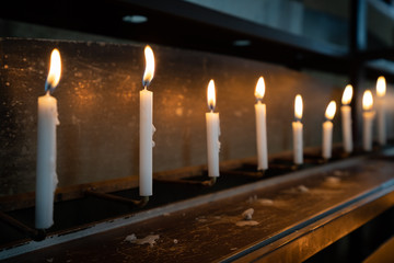 並べられた火のついたロウソクの写真