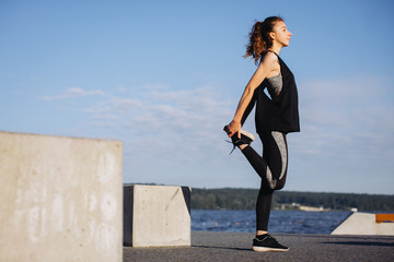 A young girl exercising by the lake