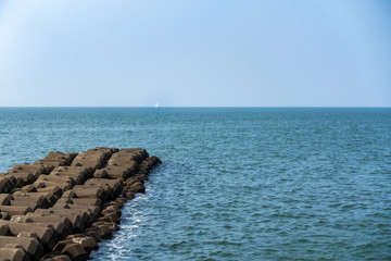 海と遠くに浮かぶヨットの写真