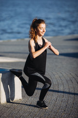 A young girl exercising by the lake