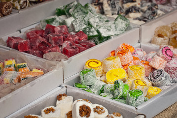 Turkish national sweets are sold at the fair. Multi-colored Asian desserts stacked on the table. Rahat lokum in bulk is sold at the festival.