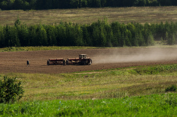 Fototapeta premium tractor cultivates field, agriculture in countryside