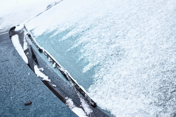  Close up of car windshield and wipers covered with ice and snow on winter day