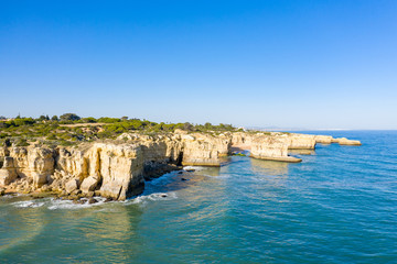 Fototapeta na wymiar Vue aérienne sur les côtes rocheuses à proximité de Albufeira. On y voit les falaises rocheuses et les plages typiques de la côte du sud du Portugal.