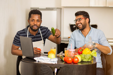 Fototapeta na wymiar Two man using laptop in kitchen