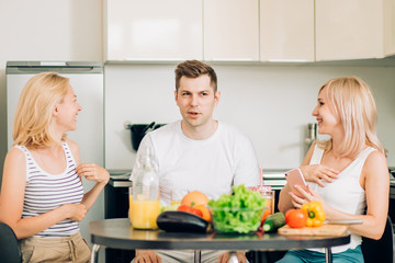 Friends sitting at table in kitchen