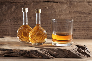 scotch whiskey in glass and mini bottle on a wooden table with a blank space for a text, scotch...