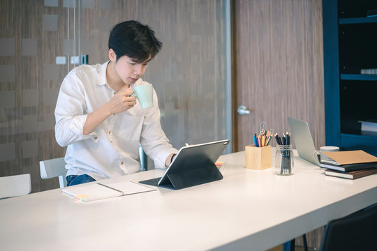 Portrait of casual young  entrepreneur businessman working in modern work station.