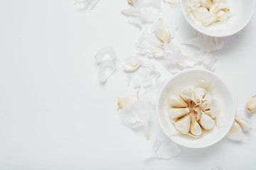 Garlic bulb, cloves and peel on white background, flat lay with copy space