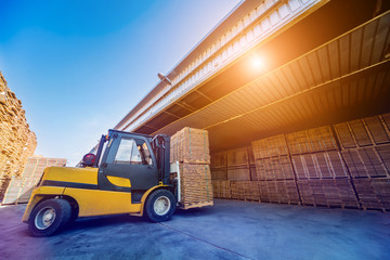 Forklift loader load lumber into a dry kiln. Wood drying in containers. © romaset