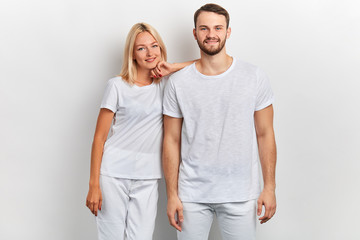 beautiful blonde girl leaning on her boyfriend's shouder and posing to the camera. family, relationship concept