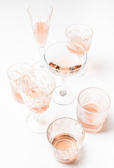 Sparkling rose wine in different glasses on white background