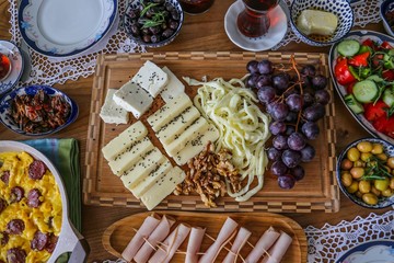 Huge healthy breakfast spread on a table with coffee, orange juice, fruit, muesli, smoked salmon, egg, croissants, meat and cheese.turkey