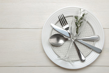 table setting. cutlery. Fork, knife, glass, spoon and plate on a white wooden table. top view