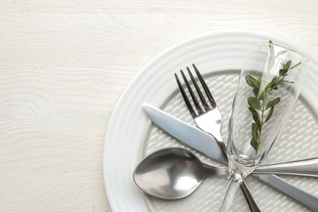 table setting. cutlery. Fork, knife, glass, spoon and plate on a white wooden table. top view