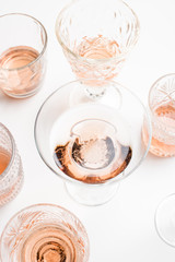 Sparkling rose wine in different glasses on white background