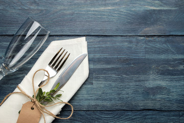 table setting. cutlery. Wine glass Fork, knife in a white napkin on a blue wooden table. top view