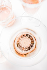 Sparkling rose wine in different glasses on white background