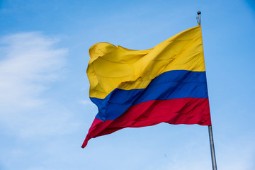 Colombian flag its yellow blue and red colors on a wavy blue background
