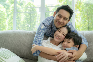 Fototapeta premium happy asian family spending time together on sofa in living room. family and home concept