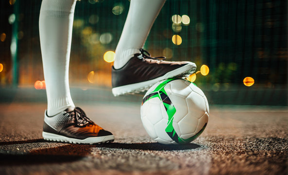 Soccer player in boots and golfs on the training ground. Soccer game concept.