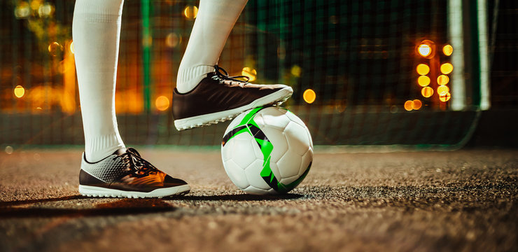Soccer player in boots and golfs on the training ground. Soccer game concept.