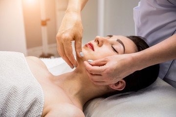 Beautiful young woman enjoying head massage in spa salon. Cosmetology