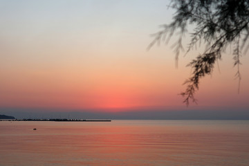 Sunset on the beach at Peraia, suburb of Thessaloniki, Greece. View of the promenade, golden sky and sea. 
