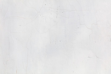 White wall with cracked plaster as abstract background