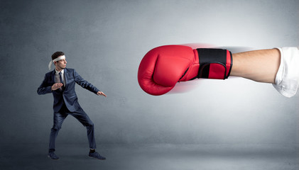 Little man fighting with a giant red boxing glove