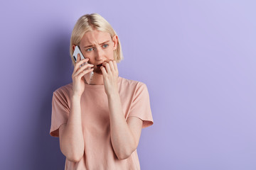 student is being worried with results of exams. isolated violet background, studio shot. copy...
