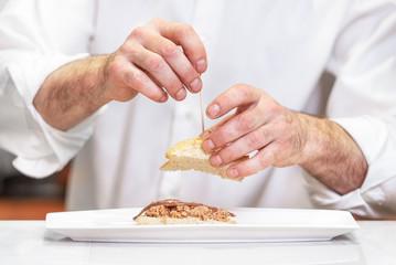 Chef preparing delicious typical Spanish food, tuna tapa or Pintxo of tuna .
