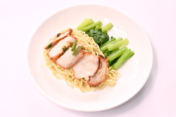 Chinese egg noodles topping slice roasted pork on plate