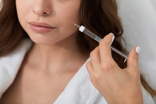 doctor holding a syringe , he is going to kill female patient. cloae up cropped photo. crime concept