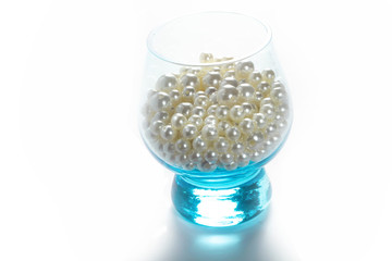 Blue glass with pearls on a white background isolate