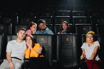 friends watching film with stunning special effects. close up photo. movie which makes audience tense and scary
